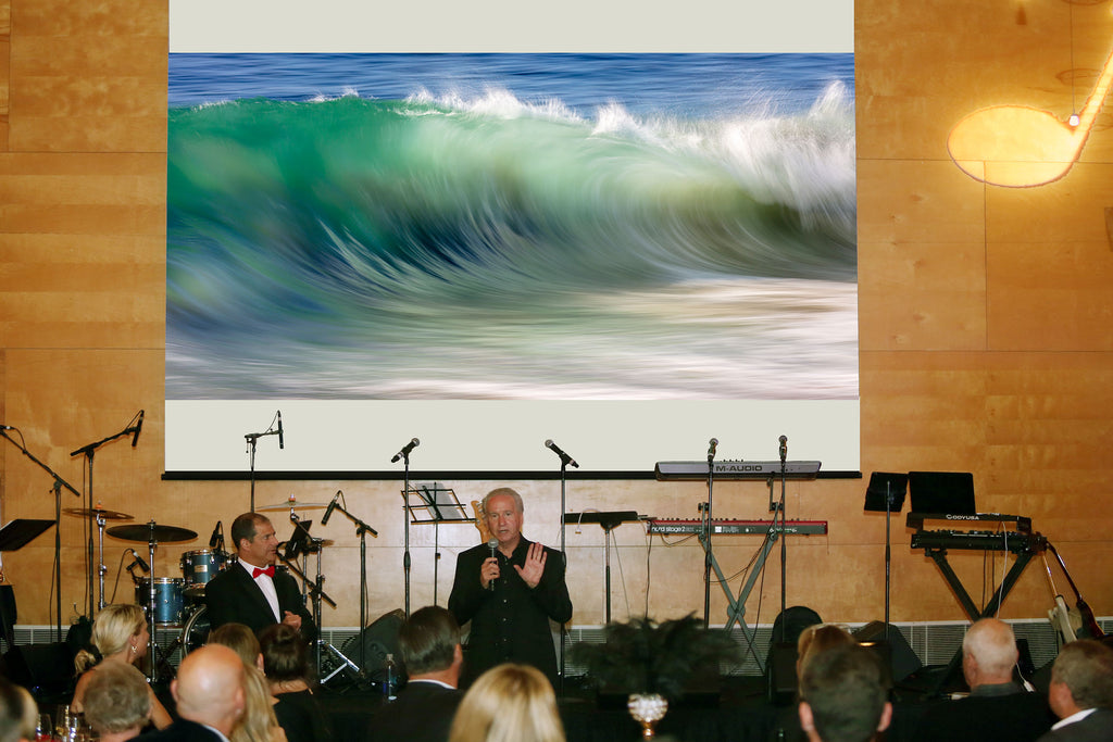 Breck Rothage with Watercolor Wall on the auction block at the Ocean Institute's Jazz 2022 fundraising gala.