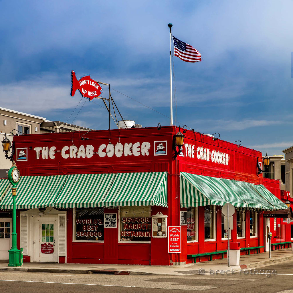 Historic and iconic Newport Beach style, Crab Cooker Corner fine art typifies casual Orange County. From the "Worlds Best Clam Chowder" sign to the "Don't Look Up Here" billboard, The Crab Cooker is one of a kind with a prominant red painted exterior and green striped awnings contrasted against the coastal blue sky.